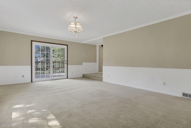 1725 Graham Dr NE, Lancaster, OH 43130 - carpeted empty room featuring a chandelier, ornamental molding, a wainscoted wall, and a textured ceiling