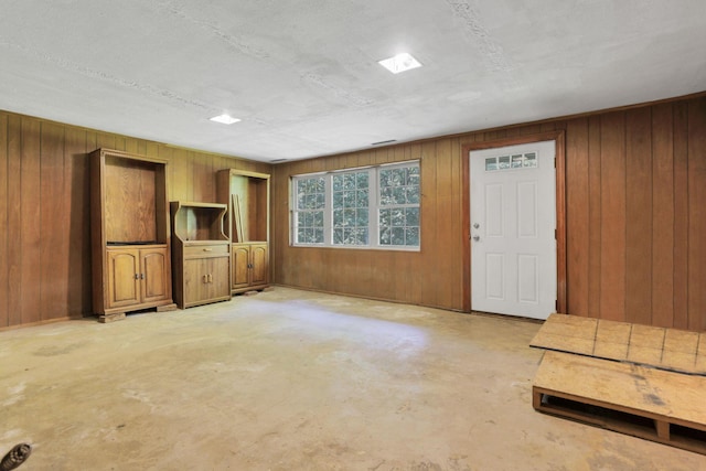 1725 Graham Dr NE, Lancaster, OH 43130 - unfurnished living room with unfinished concrete flooring and wood walls