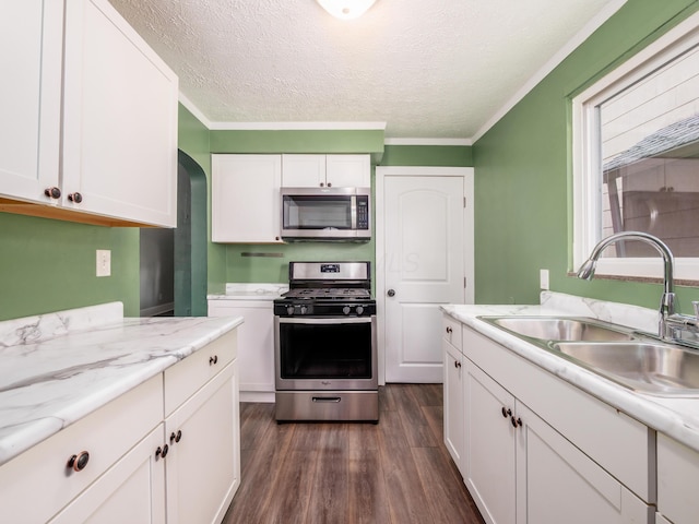 366 S Richardson Ave, Columbus, OH 43204 - kitchen with stainless steel appliances, dark wood finished floors, white cabinets, a textured ceiling, and crown molding