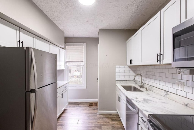 211 Buckingham St, Newark, OH 43055 - kitchen with stainless steel appliances, dark wood-style flooring, white cabinetry, tasteful backsplash, and light stone countertops