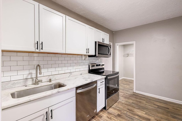 211 Buckingham St, Newark, OH 43055 - kitchen with stainless steel appliances, tasteful backsplash, white cabinetry, dark wood finished floors, and light stone countertops