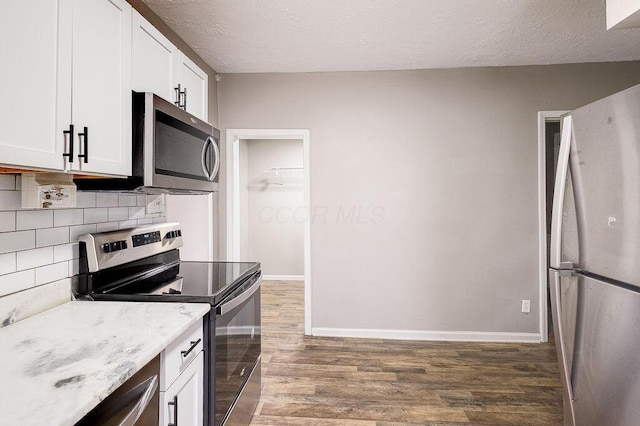 211 Buckingham St, Newark, OH 43055 - kitchen with stainless steel appliances, wood finished floors, white cabinets, a textured ceiling, and decorative backsplash