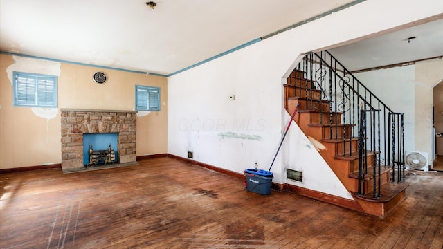 1822 W Mound St, Columbus, OH 43223 - unfurnished living room featuring wood-type flooring, a stone fireplace, stairway, and arched walkways