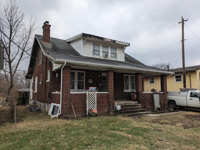 1325 Smith Rd, Columbus, OH 43207 - bungalow with a chimney, a porch, a front yard, and brick siding