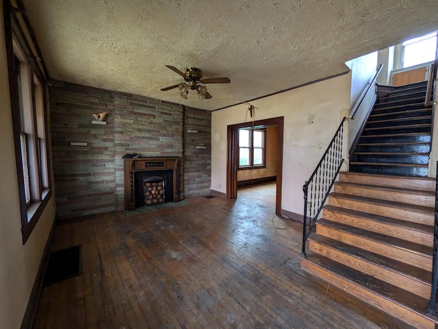 1325 Smith Rd, Columbus, OH 43207 - unfurnished living room with a textured ceiling, stairs, ceiling fan, hardwood / wood-style flooring, and a fireplace with flush hearth