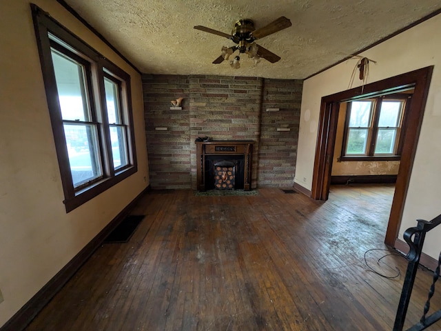 1325 Smith Rd, Columbus, OH 43207 - unfurnished living room with hardwood / wood-style flooring, a textured ceiling, ceiling fan, and a large fireplace