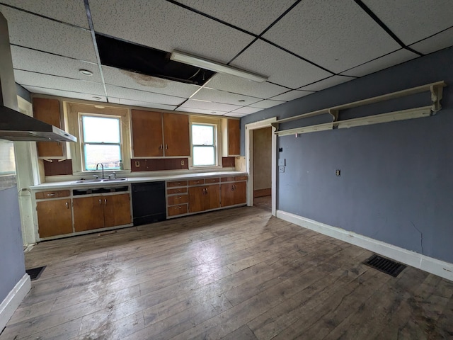 1325 Smith Rd, Columbus, OH 43207 - kitchen with black dishwasher, a paneled ceiling, brown cabinetry, light countertops, and wood-type flooring