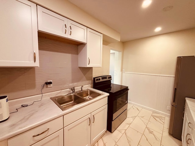 3067 E 13th Ave, Columbus, OH 43219 - kitchen with stainless steel range with electric cooktop, fridge, light marble finish floors, white cabinets, and a wainscoted wall