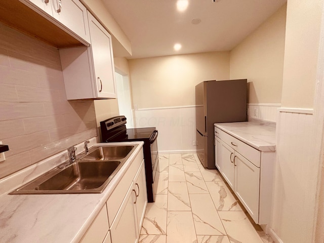 3067 E 13th Ave, Columbus, OH 43219 - kitchen with electric range oven, light marble finish floors, wainscoting, freestanding refrigerator, and white cabinets