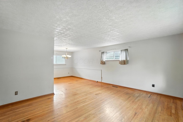3563 Astor Ave, Columbus, OH 43227 - unfurnished room featuring a chandelier, hardwood / wood-style floors, and a textured ceiling