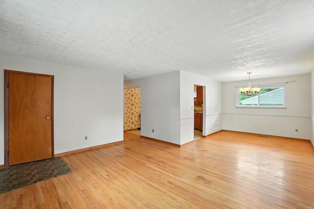 3563 Astor Ave, Columbus, OH 43227 - spare room with a chandelier, a textured ceiling, and light wood-style flooring