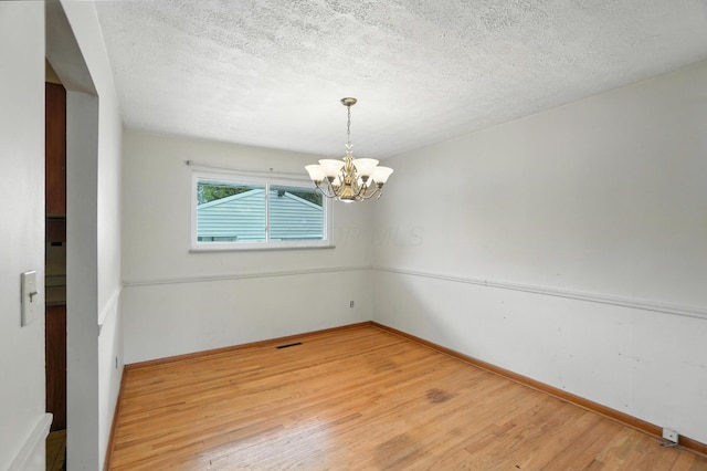 3563 Astor Ave, Columbus, OH 43227 - unfurnished room with a chandelier, wood finished floors, and a textured ceiling