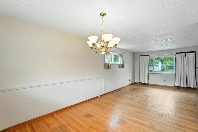 3563 Astor Ave, Columbus, OH 43227 - spare room with a chandelier, wood finished floors, and a textured ceiling