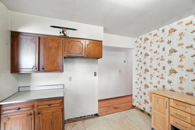 3563 Astor Ave, Columbus, OH 43227 - kitchen featuring brown cabinets, light countertops, light floors, and wallpapered walls