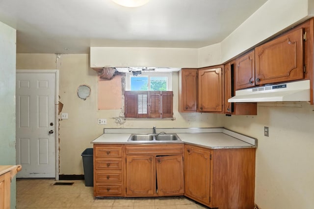 3563 Astor Ave, Columbus, OH 43227 - kitchen featuring under cabinet range hood, brown cabinetry, and light countertops