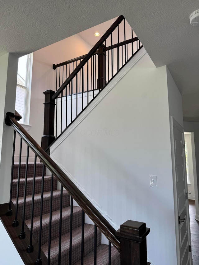 8760 Apricot Way Lot 1917, Plain City, OH 43064 - staircase featuring healthy amount of natural light and a textured ceiling