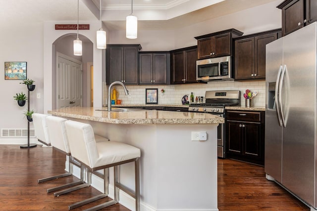 4881 Primrose Ct, Grove City, OH 43123 - kitchen with stainless steel appliances, dark wood-style flooring, backsplash, crown molding, and dark brown cabinetry