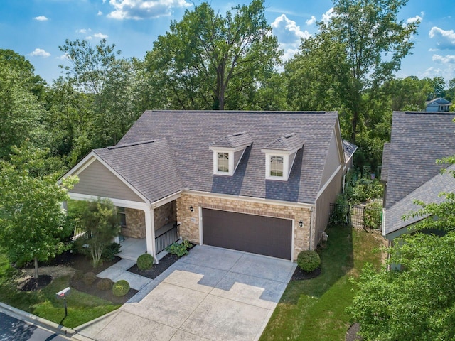 4881 Primrose Ct, Grove City, OH 43123 - view of front of house featuring stone siding, concrete driveway, covered porch, a front lawn, and a shingled roof
