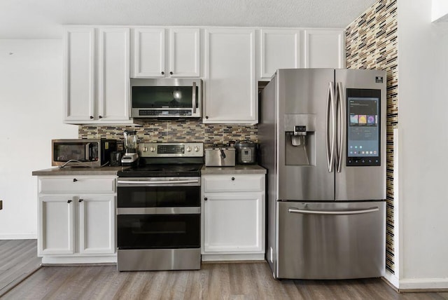 3151 Crossgate Rd, Columbus, OH 43232 - kitchen with appliances with stainless steel finishes, wood finished floors, white cabinets, and tasteful backsplash