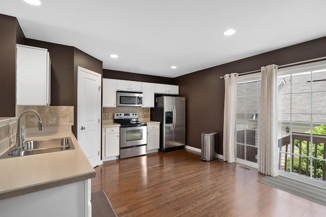 3839 Rubythroat Dr, Columbus, OH 43230 - kitchen with stainless steel appliances, white cabinetry, tasteful backsplash, light countertops, and dark wood-type flooring