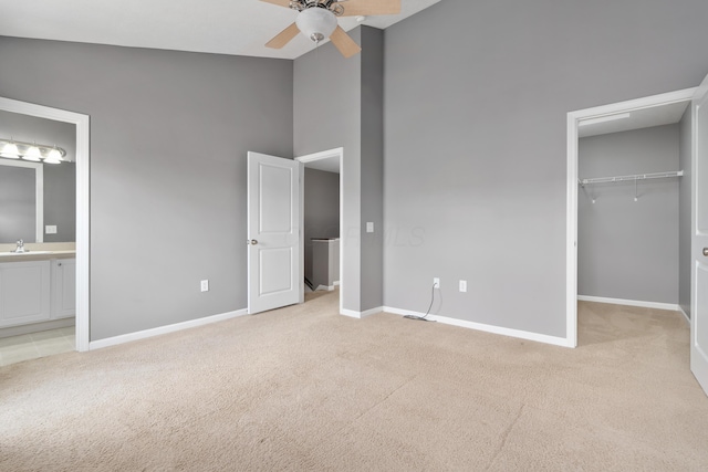 3839 Rubythroat Dr, Columbus, OH 43230 - unfurnished bedroom with carpet, a spacious closet, connected bathroom, ceiling fan, and a towering ceiling