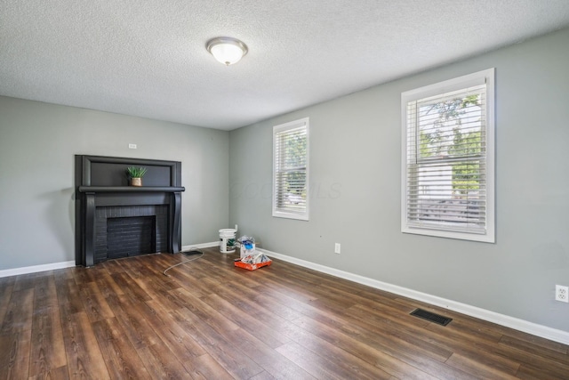2292 Traymore Pl, Columbus, OH 43211 - unfurnished living room with a brick fireplace, hardwood / wood-style flooring, and a textured ceiling