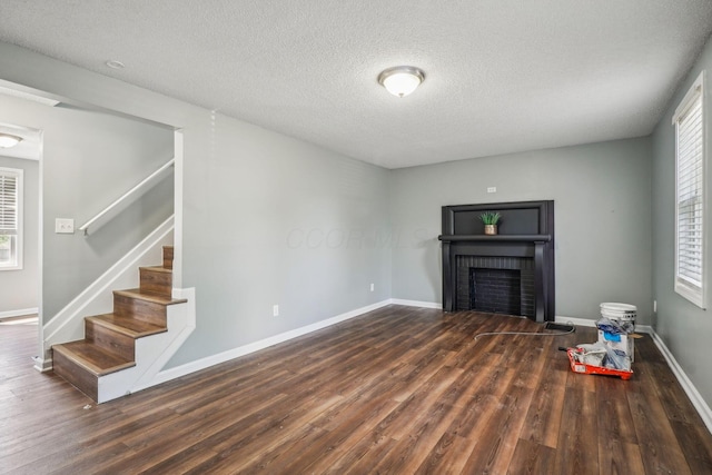 2292 Traymore Pl, Columbus, OH 43211 - unfurnished living room with wood finished floors, stairway, a textured ceiling, and a fireplace