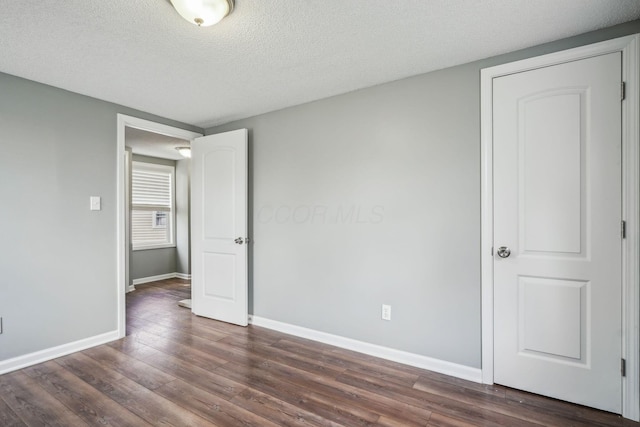 2292 Traymore Pl, Columbus, OH 43211 - unfurnished bedroom featuring dark wood-style floors and a textured ceiling
