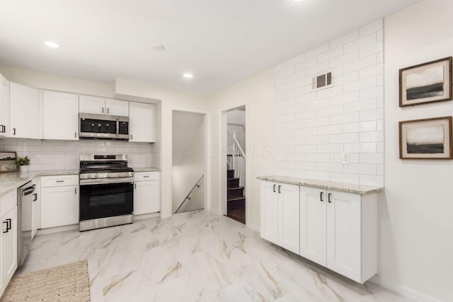 2664 Sonata Dr, Columbus, OH 43209 - kitchen with appliances with stainless steel finishes, light marble finish floors, light stone counters, white cabinets, and recessed lighting