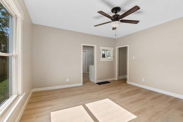 3189 E 6th Ave, Columbus, OH 43219 - unfurnished bedroom featuring multiple windows, light wood-type flooring, and ceiling fan