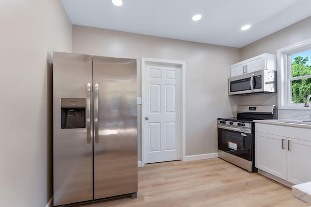3189 E 6th Ave, Columbus, OH 43219 - kitchen featuring appliances with stainless steel finishes, white cabinets, light wood finished floors, recessed lighting, and light countertops