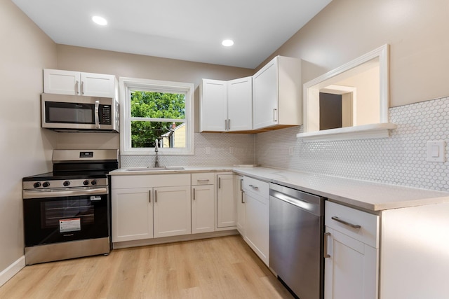 3189 E 6th Ave, Columbus, OH 43219 - kitchen with stainless steel appliances, light countertops, light wood-style flooring, white cabinets, and recessed lighting