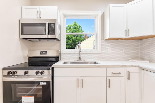 3189 E 6th Ave, Columbus, OH 43219 - kitchen with appliances with stainless steel finishes, white cabinets, decorative backsplash, and light stone countertops