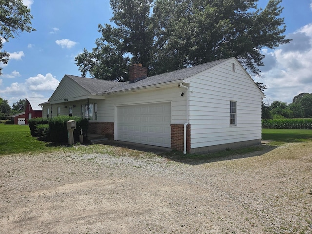 7376 Mink St SW, Pataskala, OH 43062 - view of home's exterior with brick siding, a garage, a chimney, dirt driveway, and a shingled roof