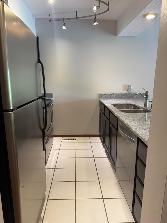 2022 Queensgate Ln, Columbus, OH 43235 - kitchen with appliances with stainless steel finishes, light tile patterned floors, track lighting, and light stone countertops