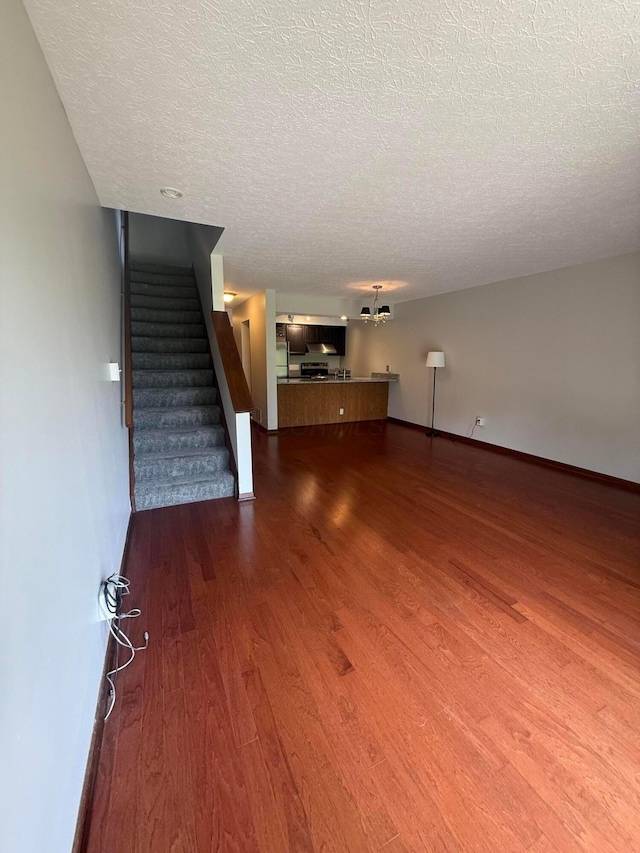 2022 Queensgate Ln, Columbus, OH 43235 - unfurnished living room with wood finished floors, a textured ceiling, and stairway