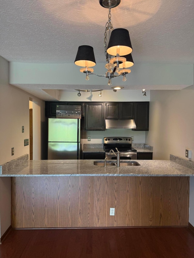 2022 Queensgate Ln, Columbus, OH 43235 - kitchen with appliances with stainless steel finishes, under cabinet range hood, wood finished floors, stone counters, and a textured ceiling