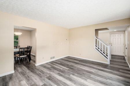 5200 Garmouth Ct, Columbus, OH 43221 - empty room with wood finished floors, stairs, and a chandelier