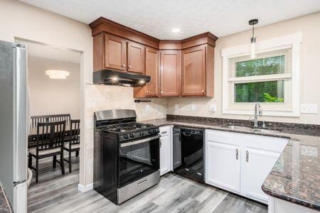 5200 Garmouth Ct, Columbus, OH 43221 - kitchen featuring appliances with stainless steel finishes, under cabinet range hood, light wood-style flooring, dark stone counters, and recessed lighting
