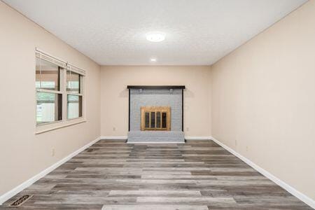5200 Garmouth Ct, Columbus, OH 43221 - unfurnished living room featuring wood finished floors and a fireplace
