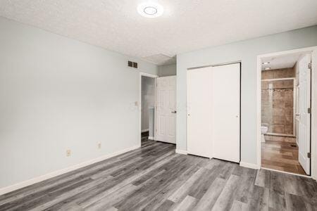 5200 Garmouth Ct, Columbus, OH 43221 - unfurnished bedroom featuring wood finished floors, a closet, and ensuite bathroom