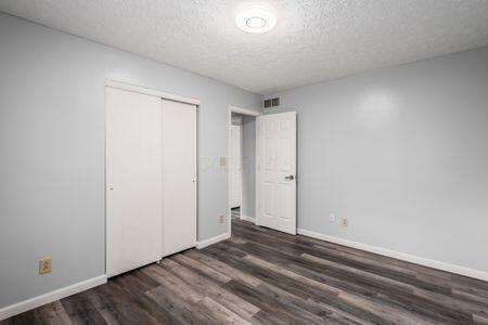 5200 Garmouth Ct, Columbus, OH 43221 - unfurnished bedroom featuring wood finished floors, a textured ceiling, and a closet