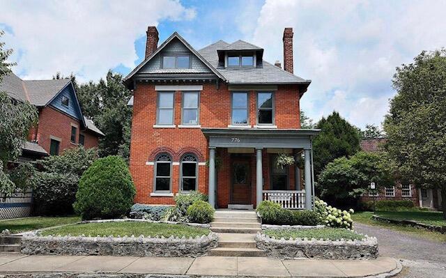 776 Oak St, Columbus, OH 43205 - view of front of home with a porch, brick siding, and a chimney