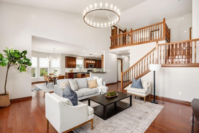 6923 Bishops Crossing Cir, Dublin, OH 43016 - living room with a chandelier, stairway, hardwood / wood-style flooring, and a towering ceiling