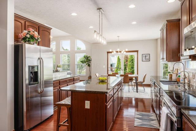 6923 Bishops Crossing Cir, Dublin, OH 43016 - kitchen with stainless steel appliances, a kitchen island, dark wood-style floors, recessed lighting, and dark stone countertops