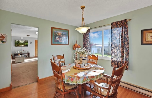 12232 Cleo Rd, Orient, OH 43146 - dining room with wood finished floors, a textured ceiling, and a baseboard radiator