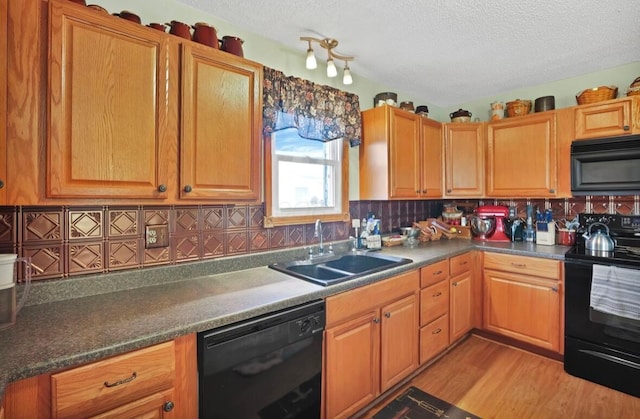 12232 Cleo Rd, Orient, OH 43146 - kitchen with black appliances, a textured ceiling, decorative backsplash, light wood finished floors, and dark countertops