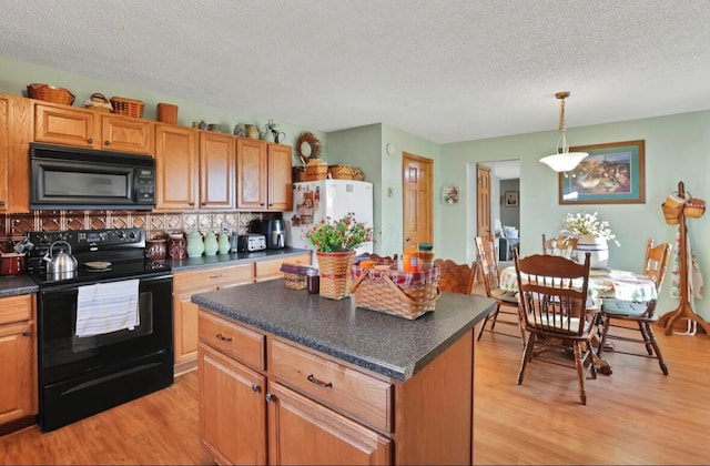12232 Cleo Rd, Orient, OH 43146 - kitchen featuring black appliances, dark countertops, light wood-style flooring, a textured ceiling, and decorative backsplash