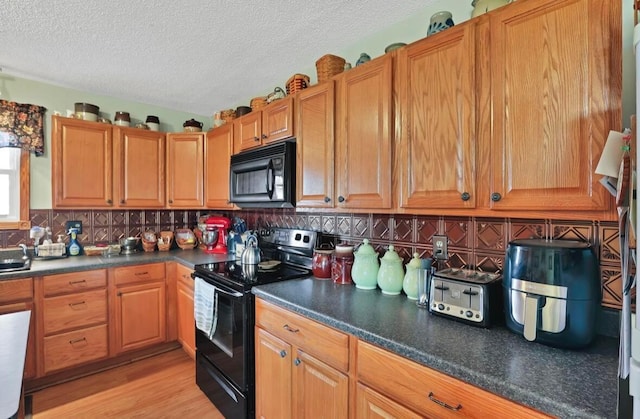 12232 Cleo Rd, Orient, OH 43146 - kitchen with black appliances, a textured ceiling, dark countertops, backsplash, and light wood-style flooring