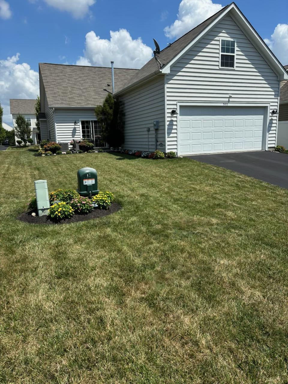 5193 Wildcat Falls Dr, Dublin, OH 43016 - view of side of home featuring asphalt driveway, a yard, and roof with shingles